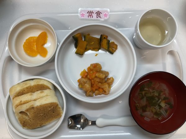 《常食》給食は米粉パン　鶏肉のオーロラソース　かぼちゃのオリーブ油焼き　スープ　みかん缶です。